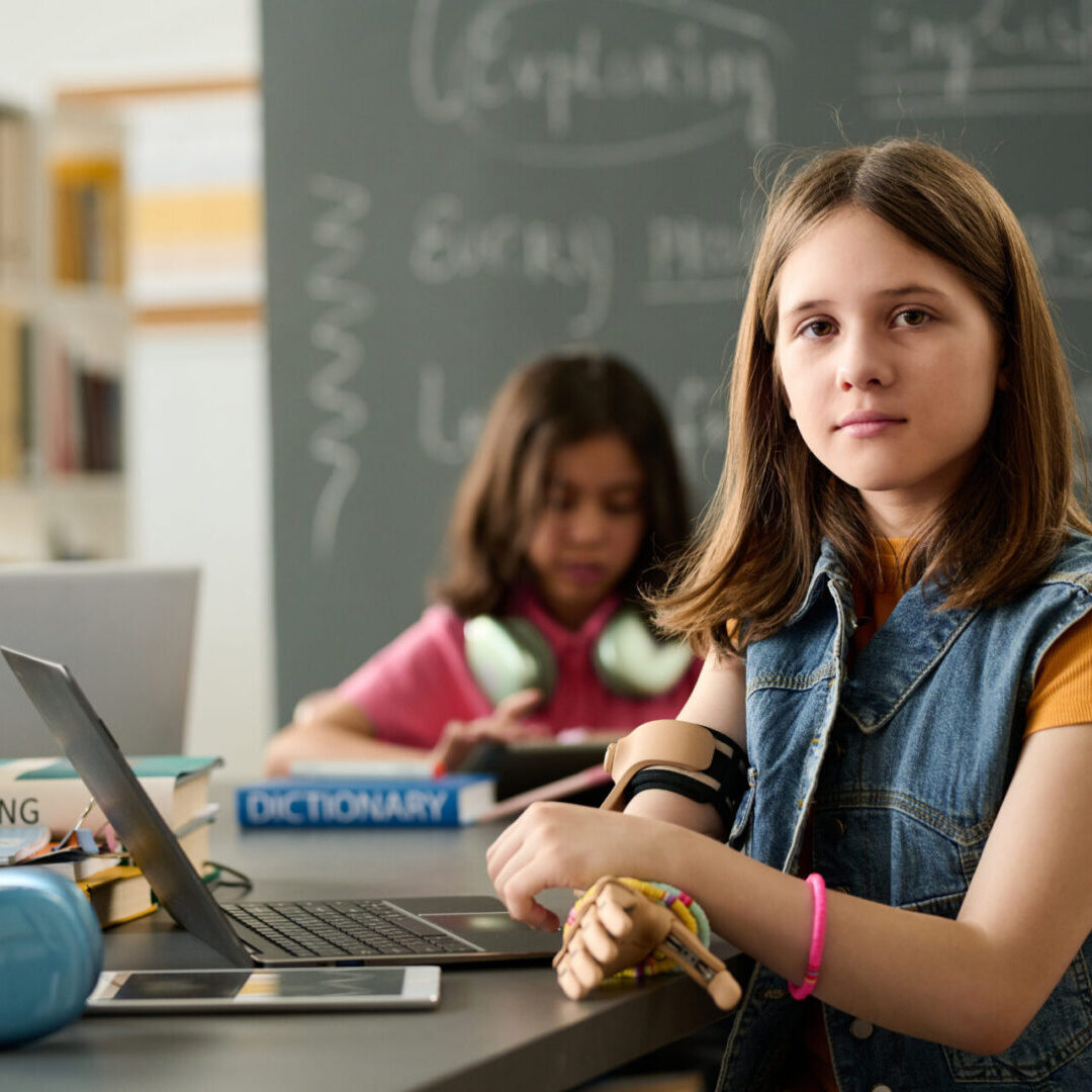 Students working on laptops in classroom.